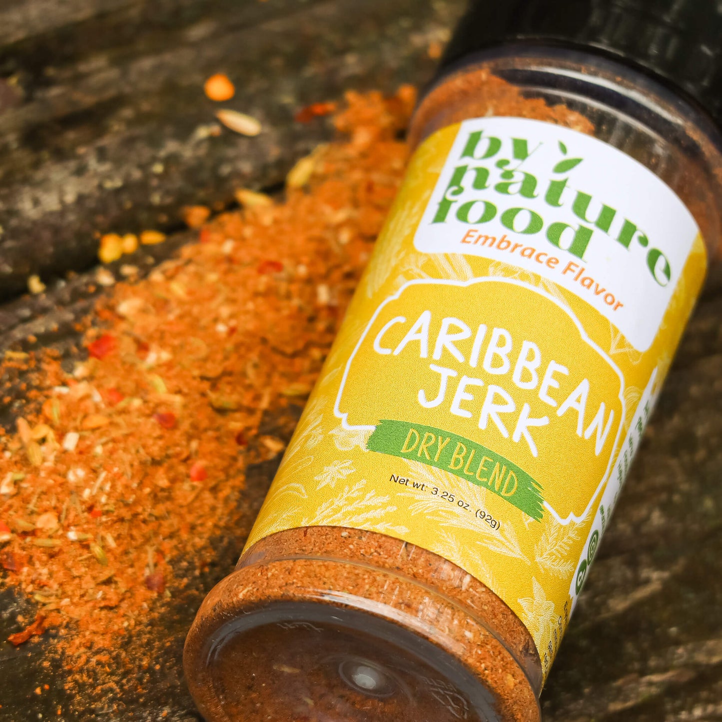 Laid flat Caribbean Jerk Seasoning container with a display of seasoning alongside