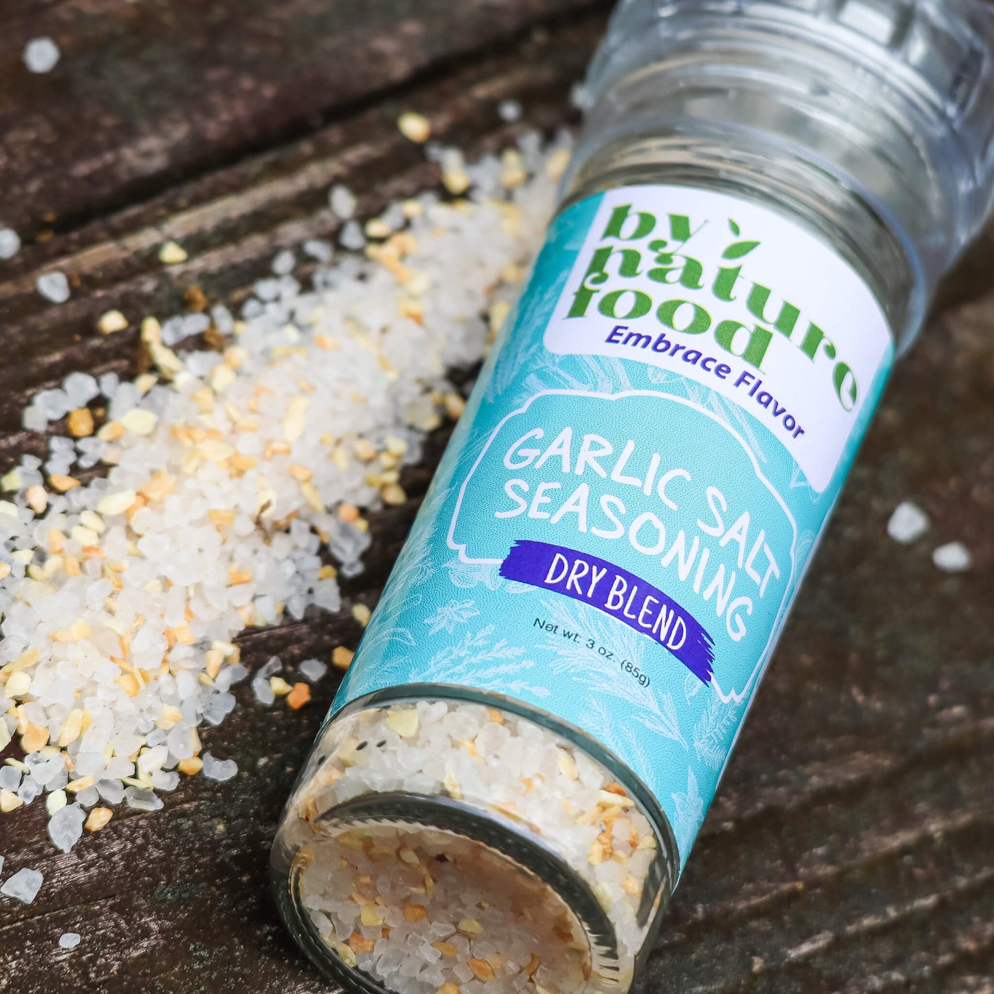 Laid flat Garlic Salt Grinder with visible salt granules alongside