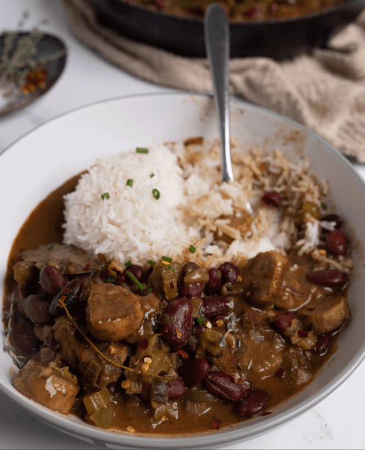 Delicious vegan red beans and rice plated and garnished with fresh herbs.